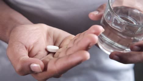 person taking a pill with water