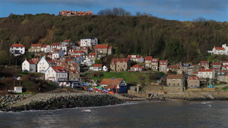 pullback establishing drone shot of runswick bay coastal village uk