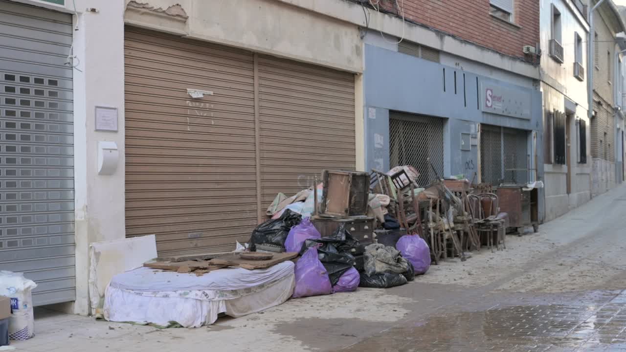 Garbage bags, furniture, and damaged buildings in an urban residential area after severe flooding in Chiva, Valencia. Effects of the DANA in Valencia