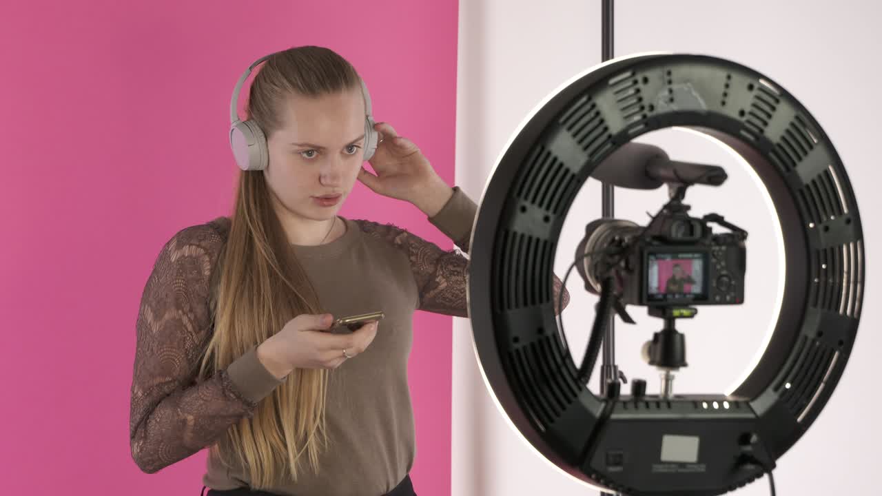una adolescente grabando un vlog para su canal de estilo de vida hablando de auriculares