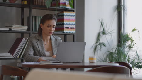 Porträt-Einer-Hispanischen-Frau,-Die-Auf-Dem-Laptop-Tippt,-Eine-E-Mail-An-Den-Kunden-Sendet-Und-Mit-Dem-Ergebnis-Zufrieden-Ist.-Geschäftsfrau-Sitzt-Am-Tisch