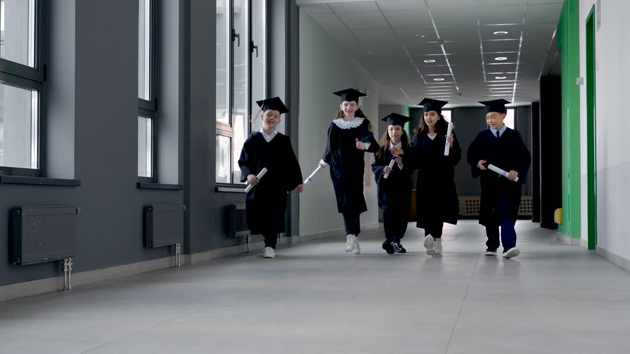 Gruppe af glade børnehavebørn i studenterhue og kappe 4
