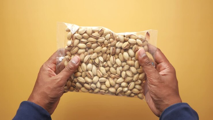 Close-up of a hand holding a bag of pistachios
