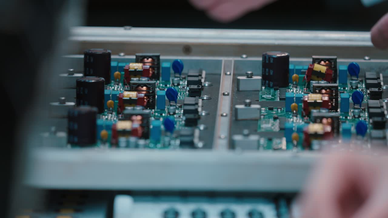 Hands assembling circuit board in slow motion, focus on precision work