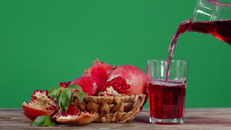 the juice of fresh pomegranates is poured into a glass.