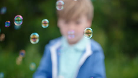 Fröhlicher-Kleiner-Junge-Fängt-Spielerisch-Schwebende-Seifenblasen-Mit-Niedlichem-Kind,-Das-Spaß-Daran-Hat,-Blasen-Im-Sonnigen-Park-Zu-Platzen.-Unbeschwertes-Kindheitsspiel-4k