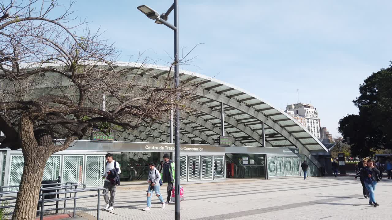 Argentine people walk at Constitución Buenos aires underground station entrance facade Panoramic establishing shot at Plaza