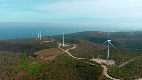 在智利北部無人居住的山脈旁邊的海邊風力發電廠的幾座風力輪的空中軌道