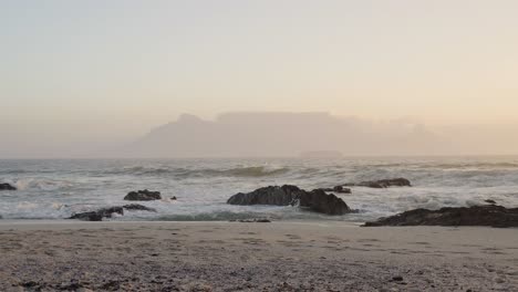 Olas-En-La-Playa-De-Blouberg-Con-Vistas-A-La-Montaña-De-La-Mesa-En-El-Horizonte