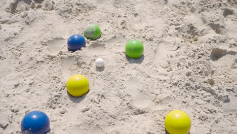 vista dall'alto di alcune palline colorate da bocce sulla spiaggia in una giornata di sole