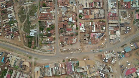 aerial view of a town and sunlit fields, golden hour in rural africa - tracking, drone shot