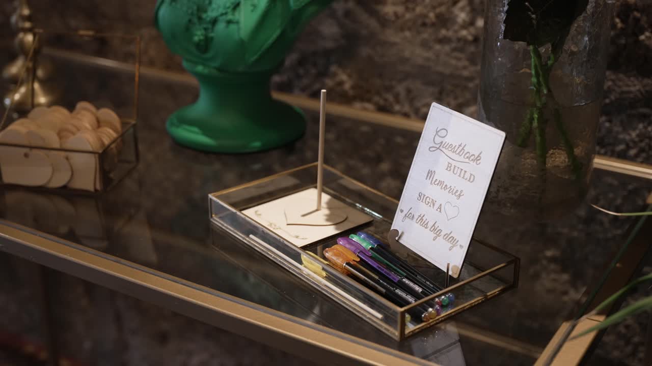 close up of wedding guestbook station with pens and wooden hearts for messages