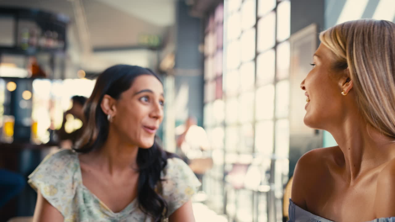 grupo multicultural de amigas que se reúnen y se ponen al día en un restaurante o una cafetería