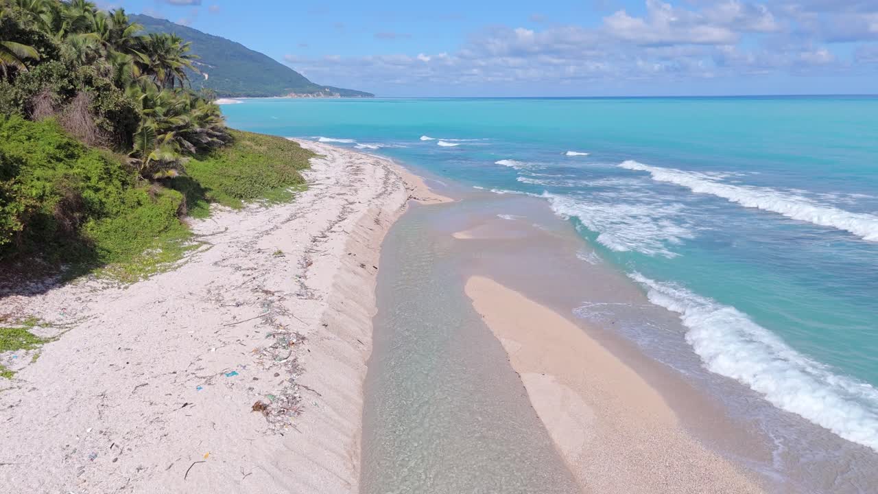 Aerial drone view of Los Patos sandy beach and river without tourists on sunny day with caribbean blue ocean in background, Dominican Republic