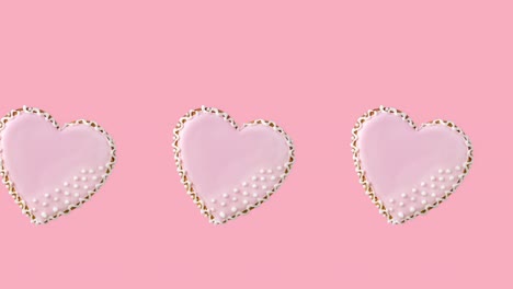 animación de bucle sin costuras con una fila de galletas en forma de corazón decoradas con esmaltes rosados en un fondo pastel