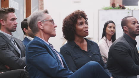 mature businessman and businesswoman having discussion during presentation at conference