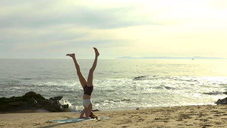 An-attractive-young-woman-practicing-yoga-on-a-beautiful-California-beach