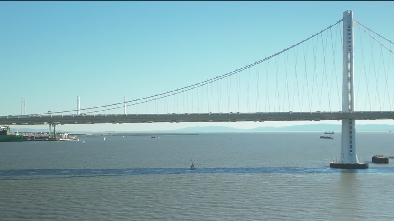 Aerial drone shot close to San Francisco-Oakland Bay Bridge with blue sky in California, USA