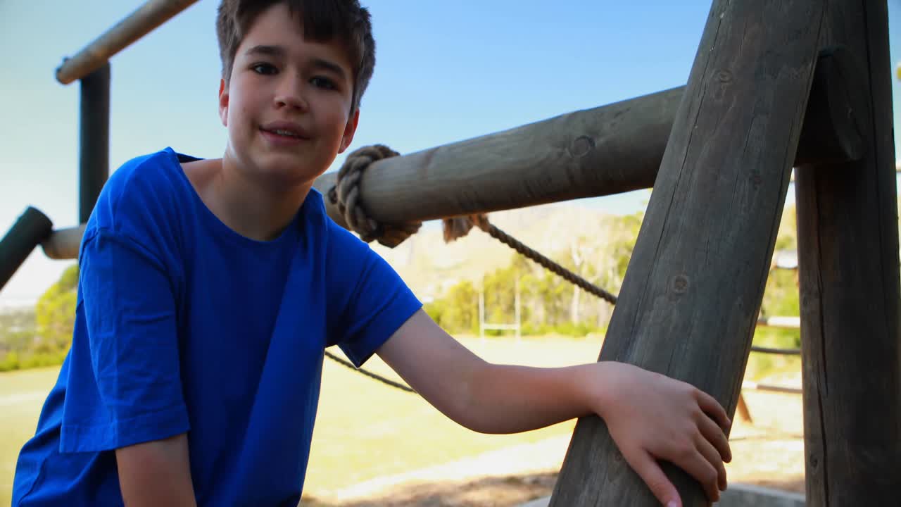 retrato de un niño feliz sentado en equipos al aire libre durante una carrera de obstáculos