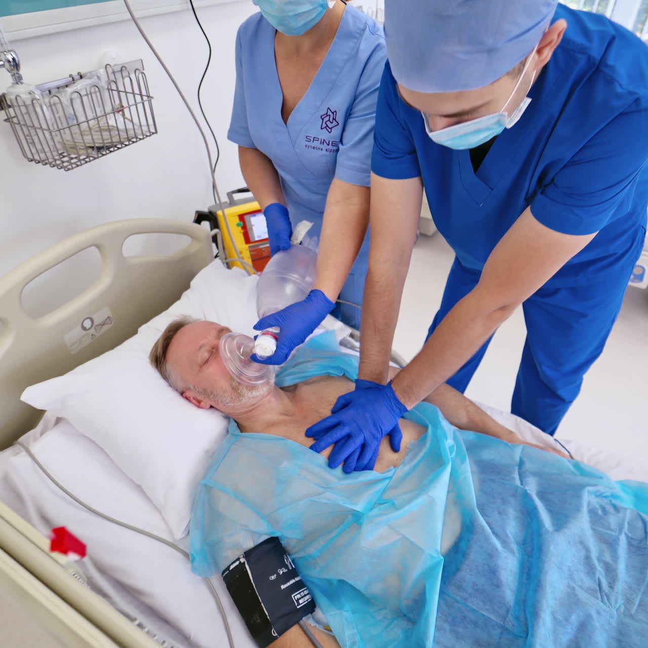 Top view of unconscious patient in emergency room. Specialist man and a nurse save patient without breathing in clinic. Emergency concept.