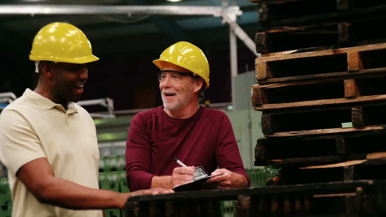 trabajadores escribiendo en el clipboard mientras interactúan entre sí