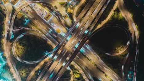 time-lapse or hyper-lapse zoom out aerial view highway road roundabout circle or intersection traffic at night for transportation concept.