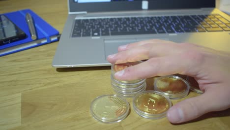 male businessman at work holding physical golden bitcoin in his hand and push them at the side