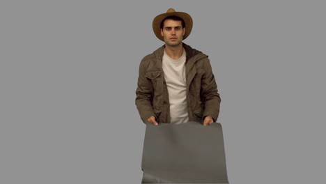 hombre desplegando una bolsa de dormir en la pantalla gris