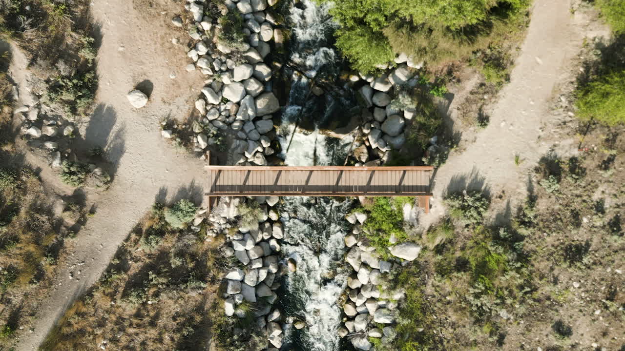 puente de madera a través de un río que fluye en bell canyon, utah arenoso