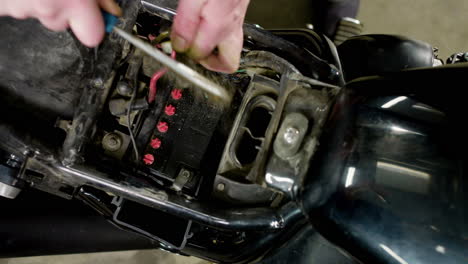 man repairing a motorcycle