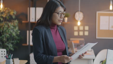 businesswoman reading documents in modern office