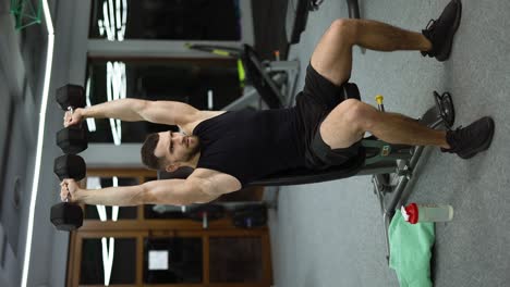 Junger-Attraktiver-Muskelsportler-Trainiert-In-Einem-Modernen-Fitnessstudio-Mit-Hanteln