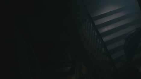 a bald man walks on the empty hospital staircase at night