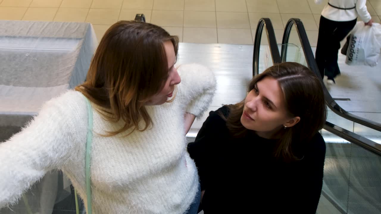 쇼핑몰 의 에스컬레이터 에서 이야기 하는 두 여자