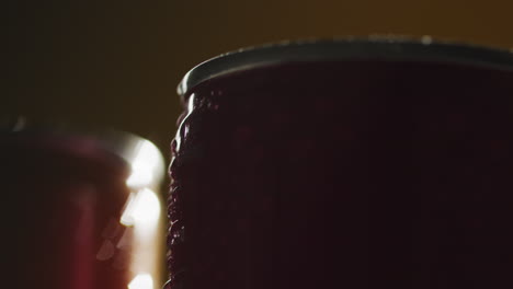 close up backlit shot of condensation droplets on revolving takeaway cans of cold beer or soft drinks 1