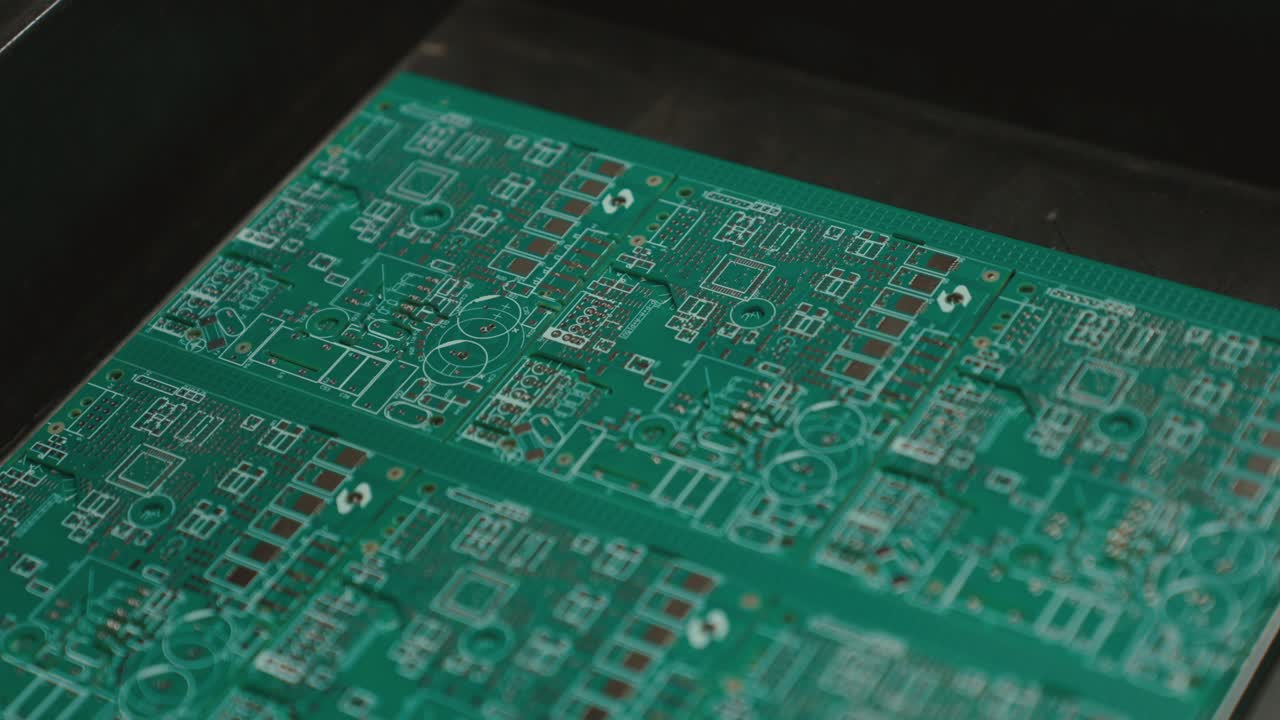 Slow motion close-up of circuit boards in a tech assembly line