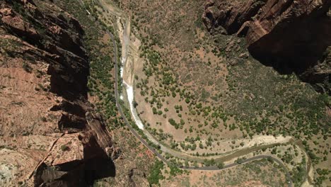 Aerial-drone-footage-offering-a-bird's-eye-view-of-Zion-National-Park,-highlighting-the-rock-formations-and-the-remnants-of-water-flow