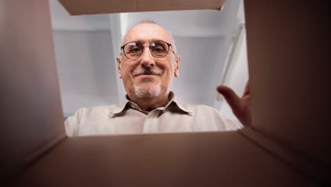 feliz envejecido anciano de 70 años hombre abriendo caja de cartón deseado compra tienda digital mercado orden
