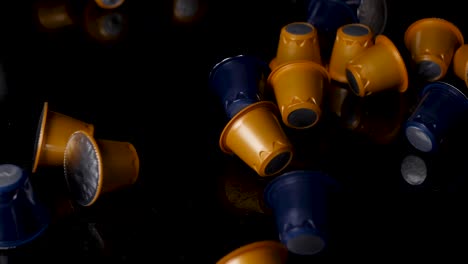 variety of coffee pods blue and yellow color fall on black surface
