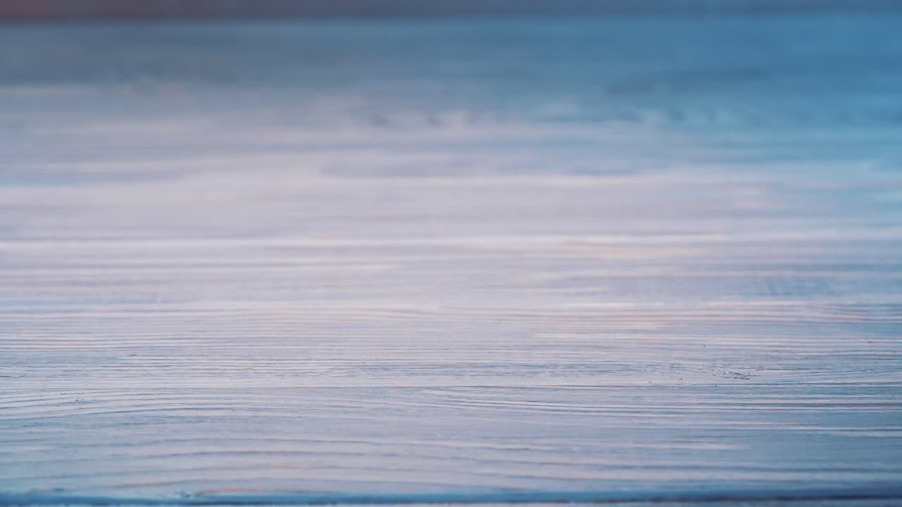 Modern white touchscreen phone is falling on the floor and crashes isolated on the wooden background floor. Broken smartphone on the grey surface.