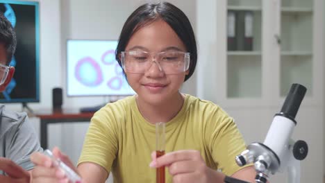 young asian boy and girl learning science experiment in laboratory at classroom. study with scientific equipment and test tubes