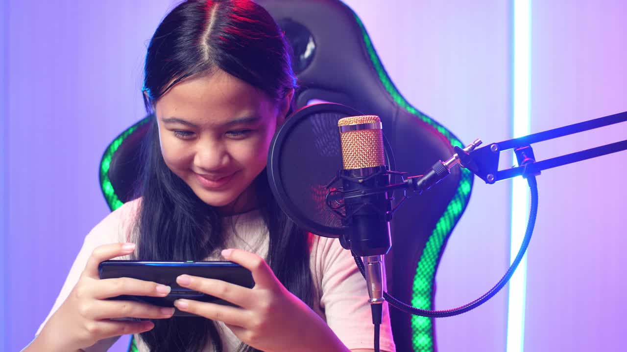 Excited Asian Kid Girl Playing Video Game With Mobile Phone While Live Stream