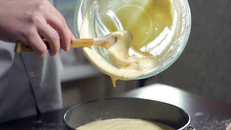 Man-extracting-liquid-cake-batter-from-mixing-bowl.-Baking-cake.-Home-baking