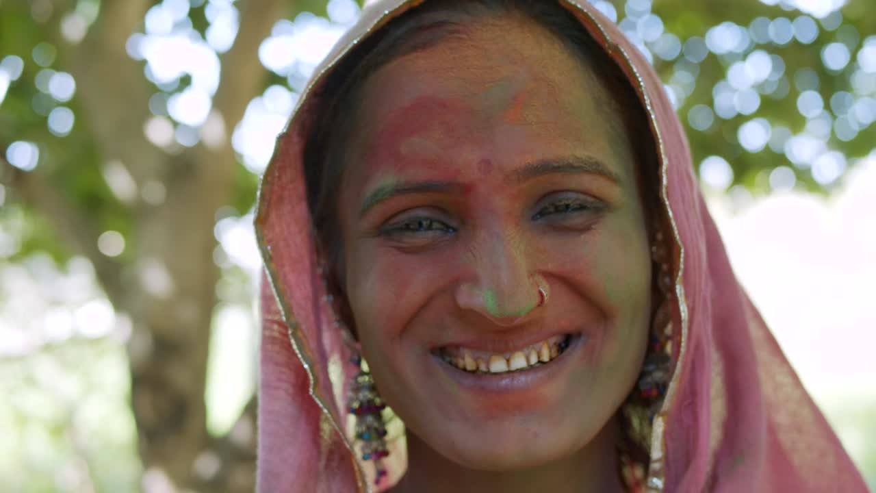 mujeres indias de primer plano de la cara manchada con colores brillantes de holi