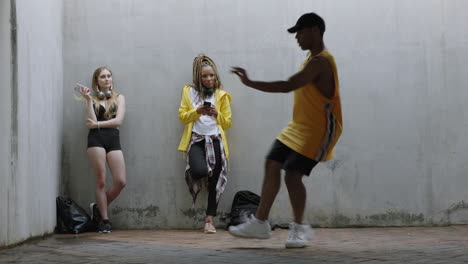 Hombre-Bailando-Joven-Bailarín-Callejero-Feliz-Realizando-Movimientos-De-Estilo-Libre-Amigos-Viendo-Disfrutando-De-La-Danza-En-Un-Almacén-Urbano-Sucio