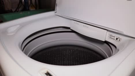 putting dirty laundry and a detergent pod into a washing machine