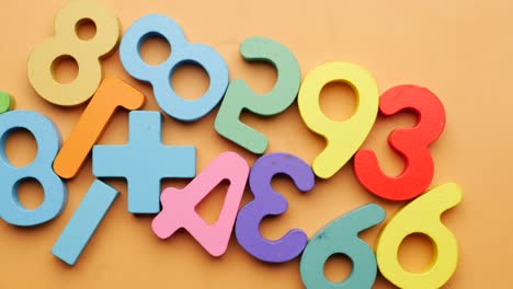 Ful-plastic-numbers-on-orange-background,-top-view