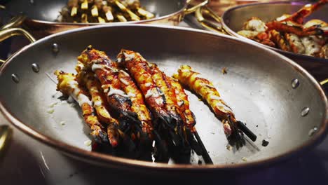 juicy grilled prawns served hot from the pan at a festive party at night