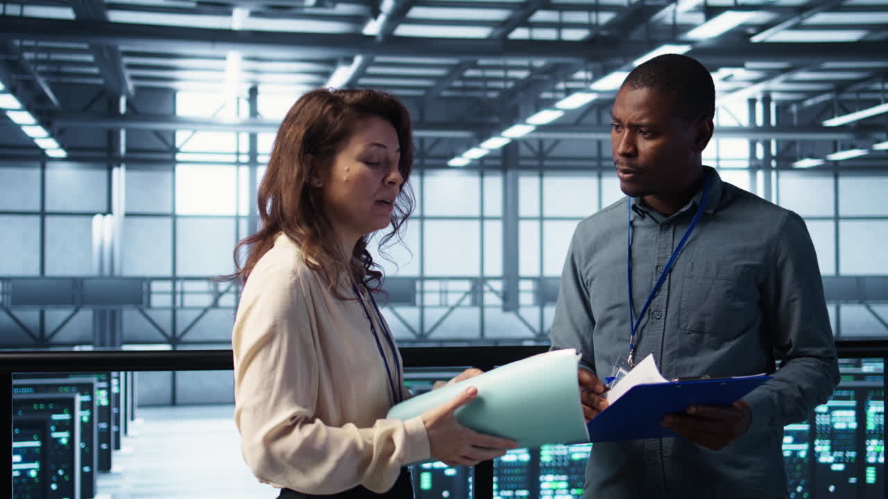 ingeniero de centro de datos saludando a un colega, examinando el papeleo de diagnóstico del sistema