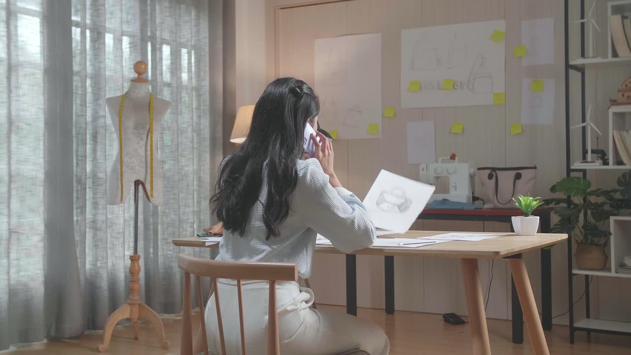 여성 디자이너가 드백을 보고 스마트폰으로 대화하는 모습